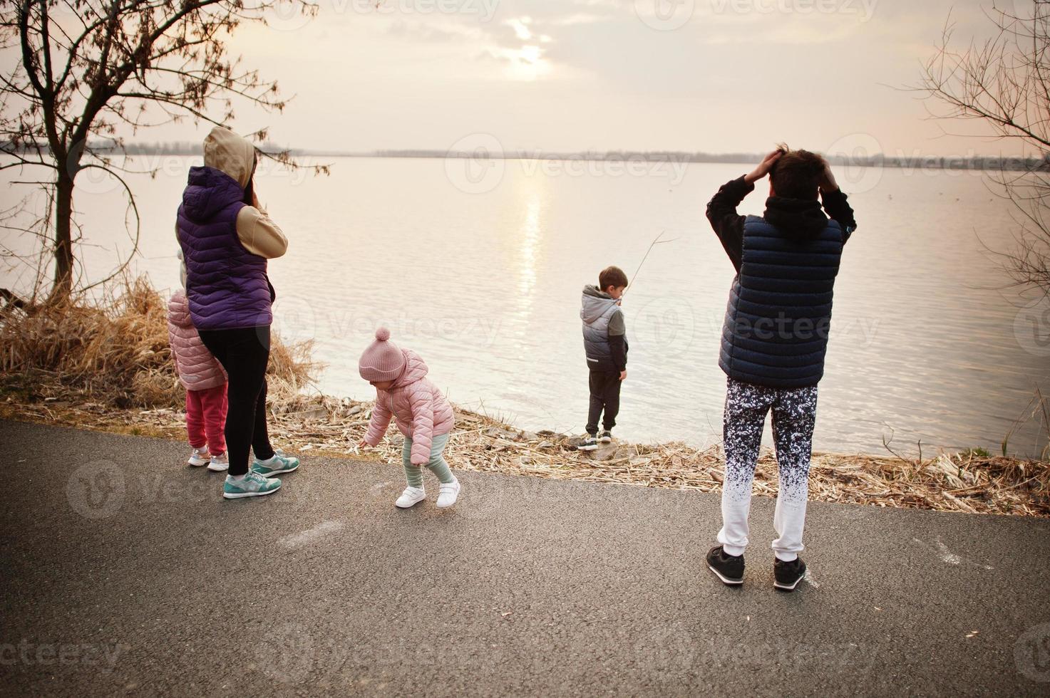 mãe com filhos na margem do lago. foto