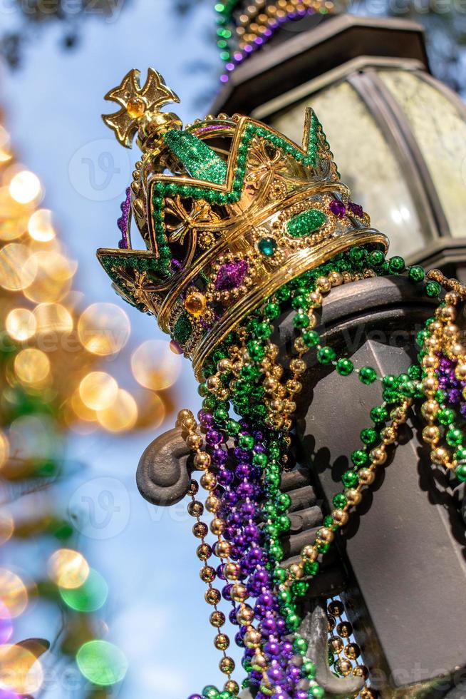 coroa de carnaval ao ar livre e miçangas no poste de luz no sol foto