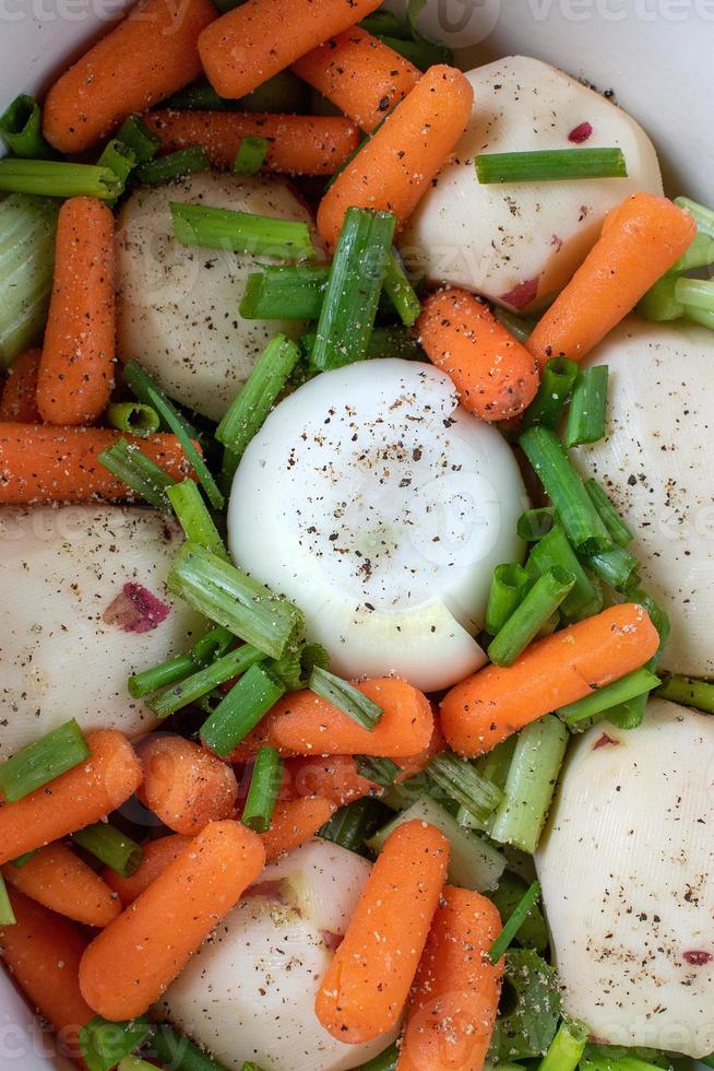 panela de guisado com legumes de batatas, cenouras e cebolas com ervas foto