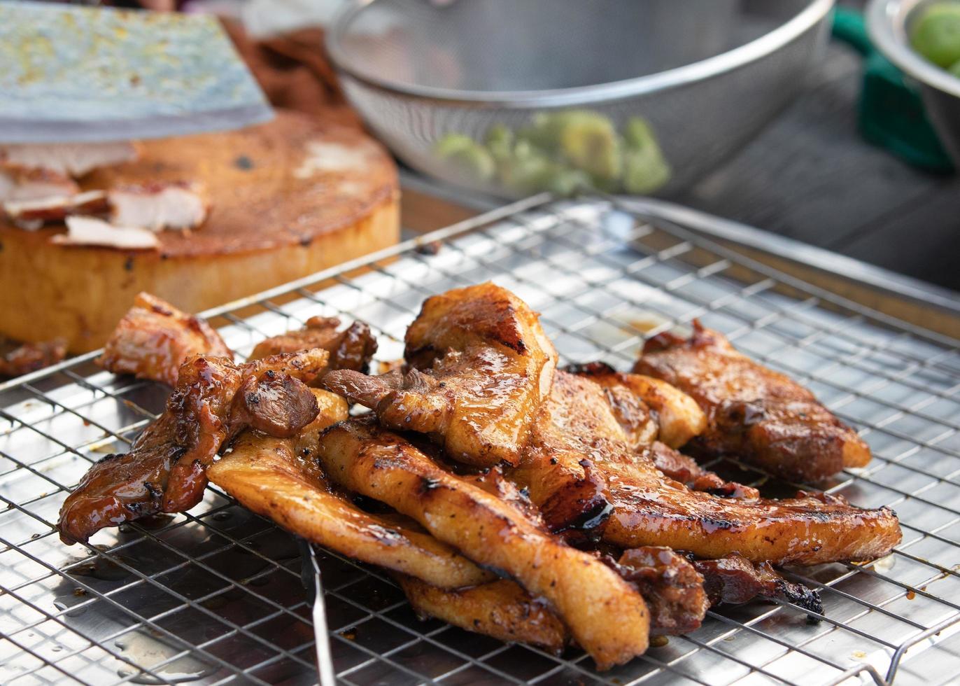 pescoço de porco grelhado marinado grelhado com molho temperado na grelha em comida de rua na tailândia. conceito de comida de rua tailandesa asiática foto