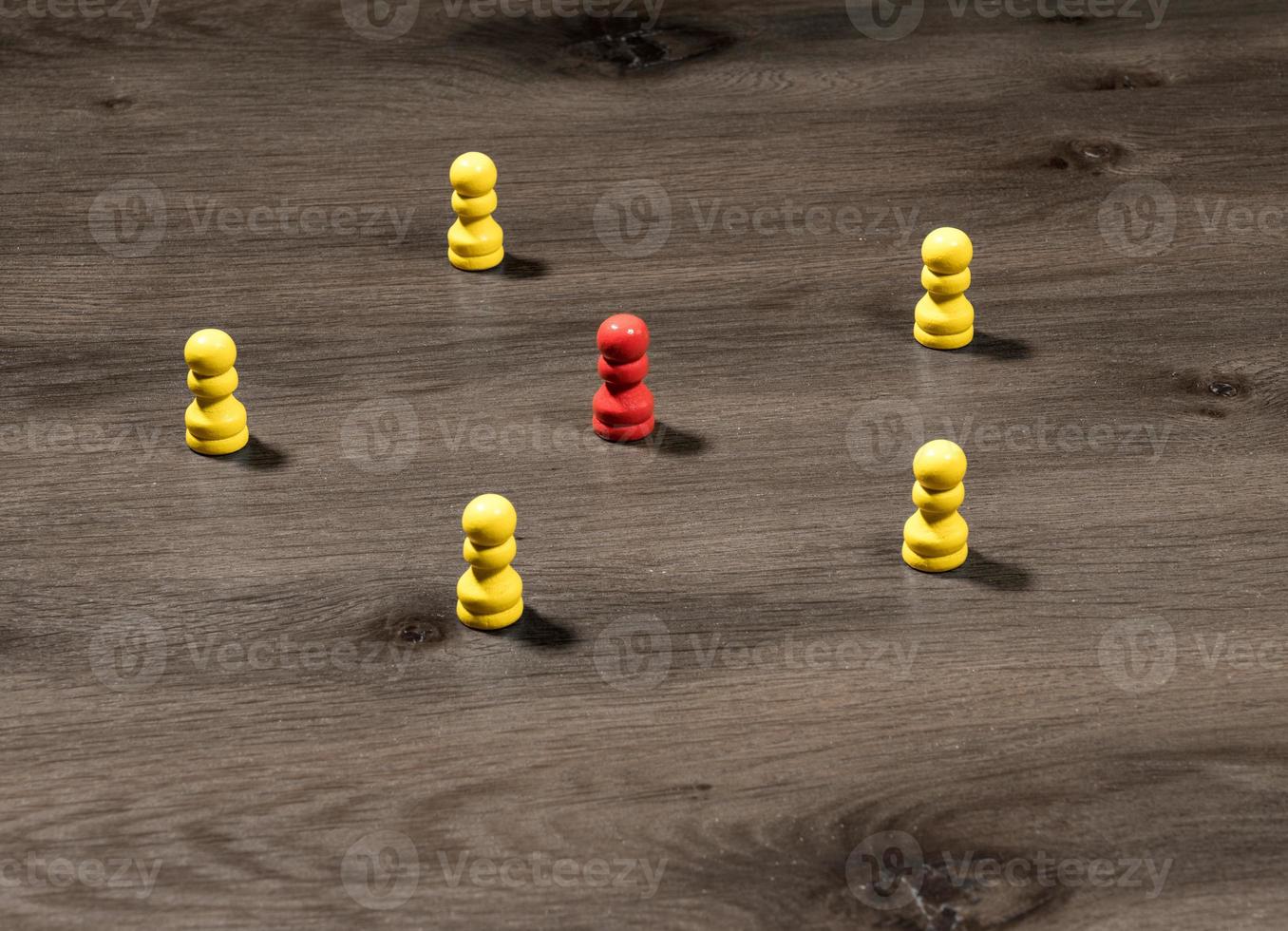 pinos de madeira amarelos ao redor do vermelho para ilustrar liderança ou comunicação de mídia social foto
