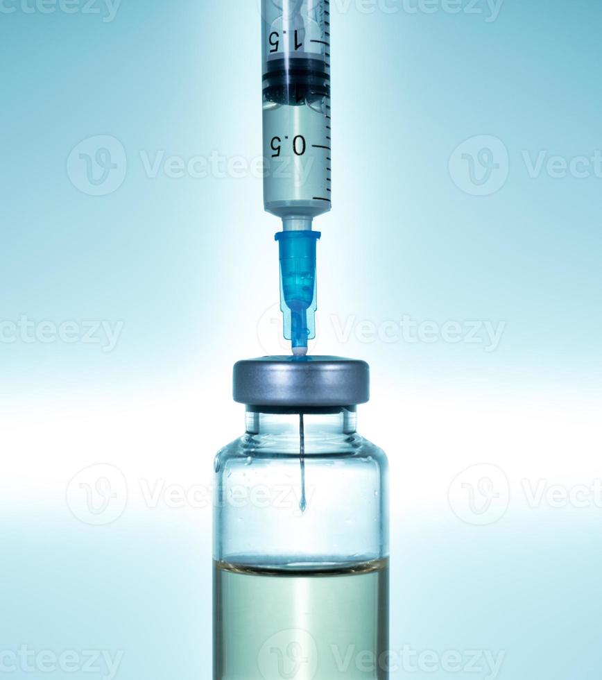 agulha de seringa hipodérmica inserida em uma ampola ou garrafa de vacina foto