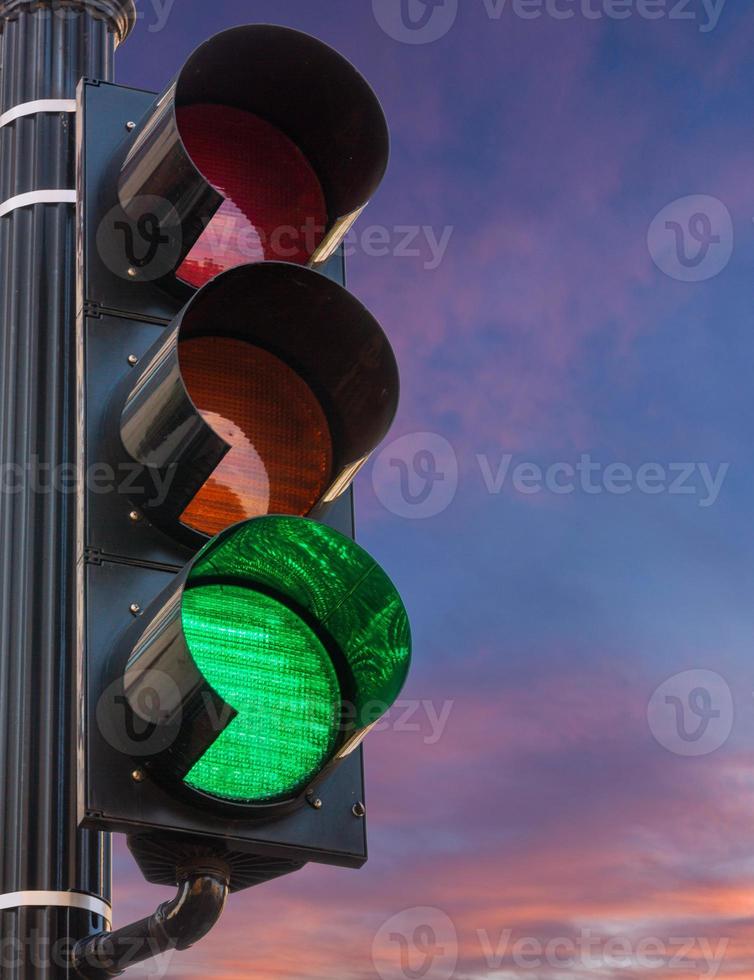 luz verde no sinal de trânsito contra o nascer do sol como conceito de esperança foto