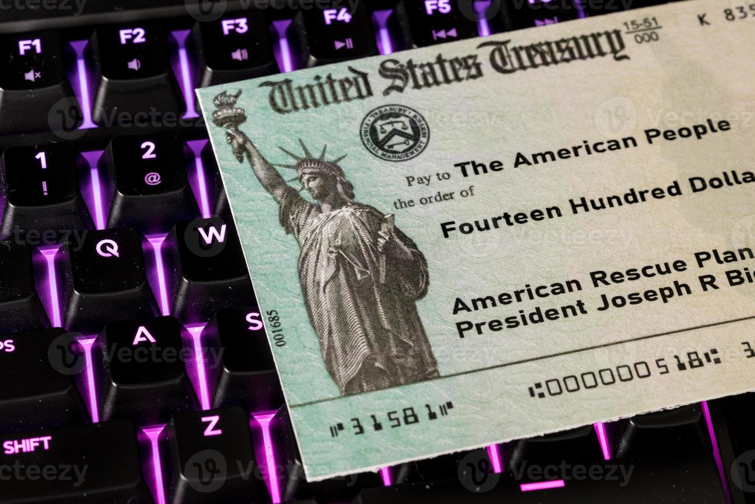 ilustração do cheque de pagamento de estímulo federal do irs no teclado foto