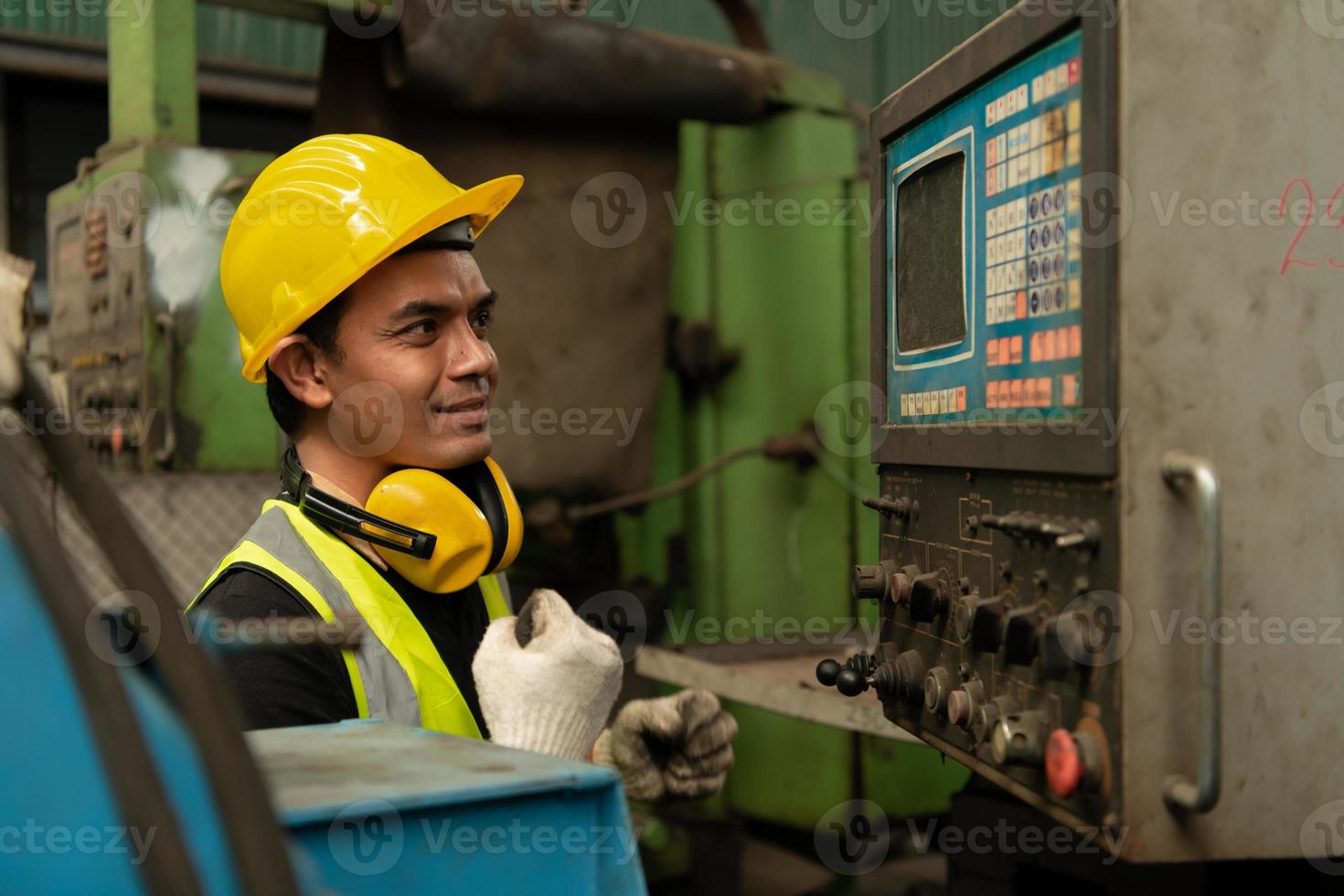 mecânico asiático trabalhando em uma fábrica mecânica reparando máquinas antigas foto