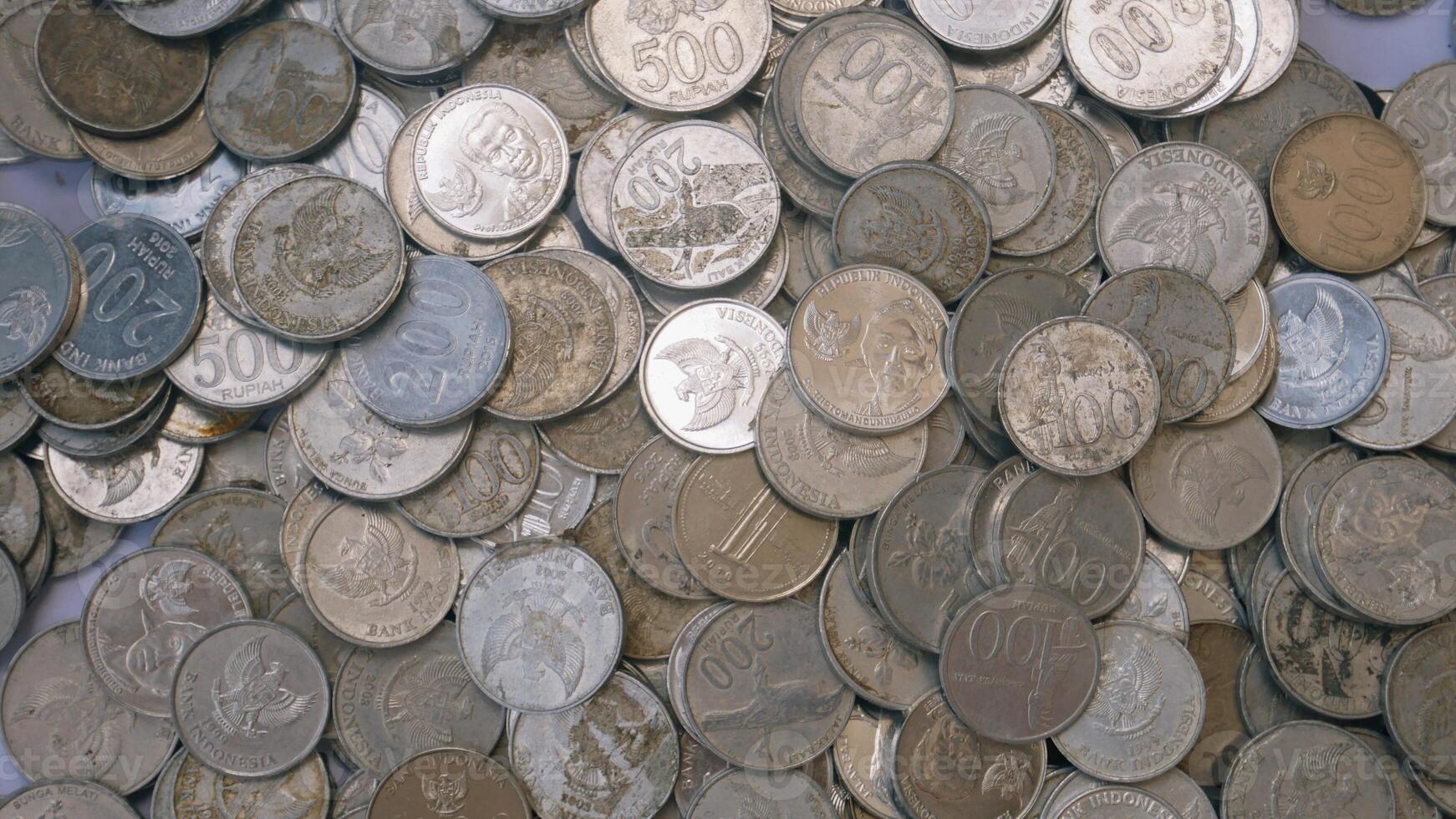 pilha de moedas de rupia indonésia no fundo branco, luz brilhante leve foto