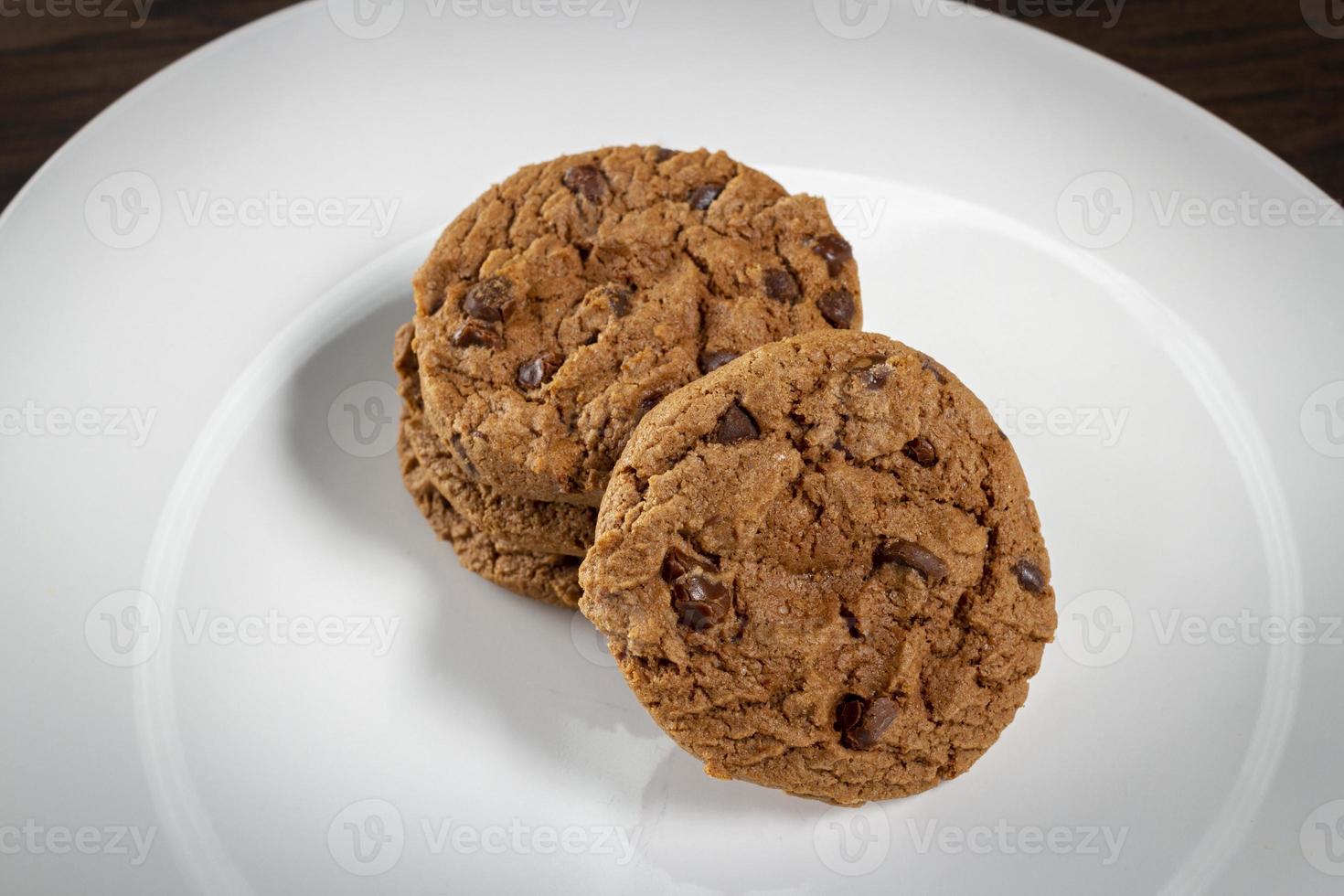 prato de biscoitos de chocolate recém-assados. fundo de madeira, foco seletivo foto