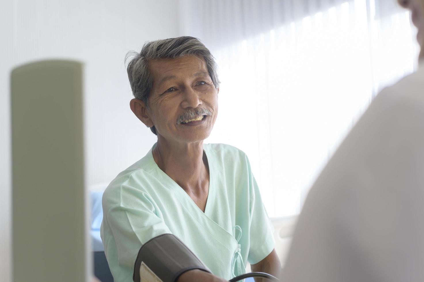 paciente masculino sênior asiático está consultando e visitando médico no hospital.. foto