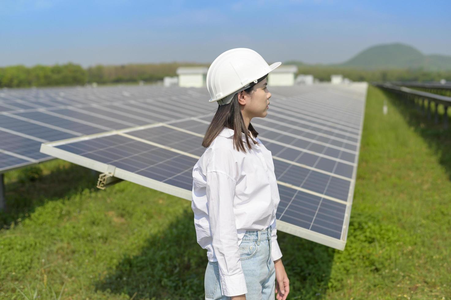 engenheira usando capacete em fazenda de células fotovoltaicas ou campo de painéis solares, energia ecológica e limpa. foto