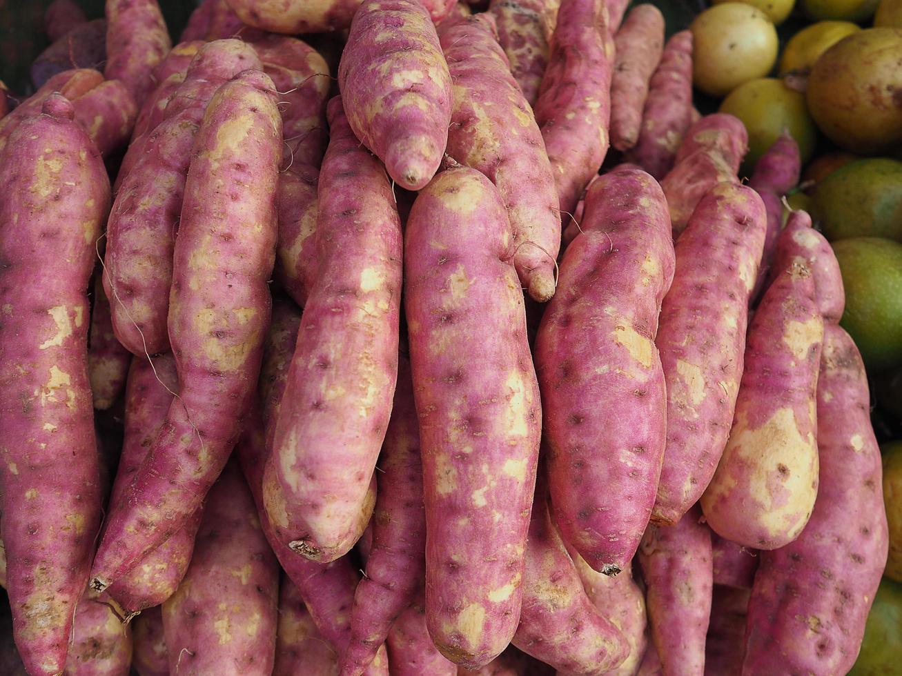 pilha de inhame roxo fresco orgânico para venda no mercado foto