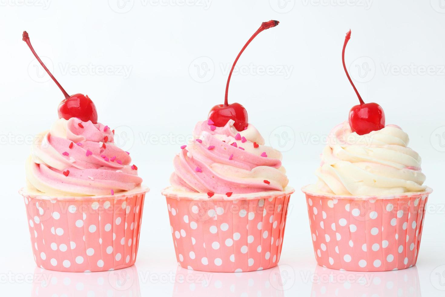 cupcake com chantilly e cereja isolado no branco foto