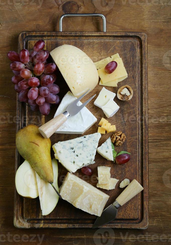 tabuleiro de queijos com queijos variados (parmesão, brie, azul, queijo cheddar) foto