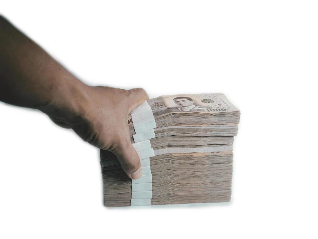 a mão de um homem segurando uma nota de 1000 baht empilhadas juntos montante total 1000000 baht em um fundo branco. foto