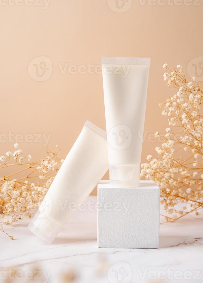 maquete de tubo de creme para apresentação de marca. produto de beleza natural para a pele no pódio branco quadrado. cores terrosas naturais foto