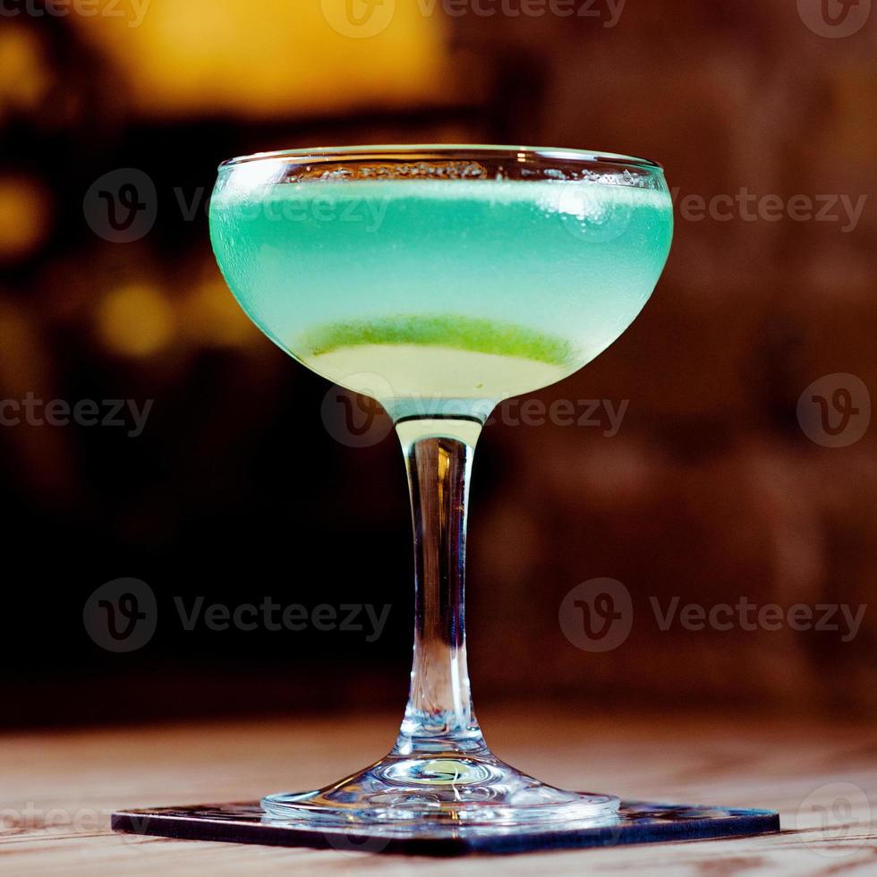 verde e azul com coquetel de álcool de limão no copo sobre a mesa no bar foto