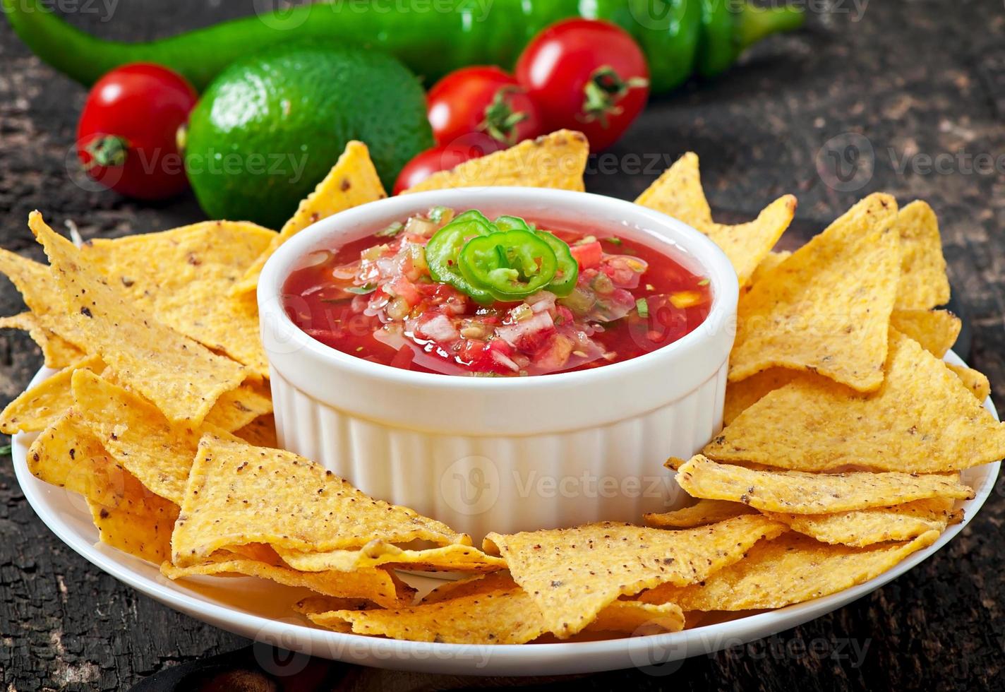 chips de nacho mexicano e molho de salsa na tigela sobre fundo de madeira foto