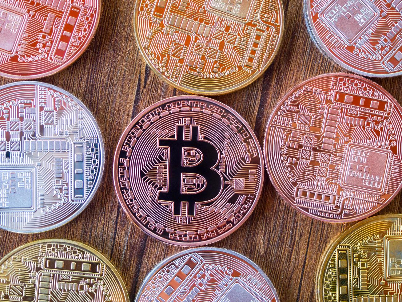bitcoins são cobre, ouro e prata, que estão na moeda digital. em um fundo de madeira foto