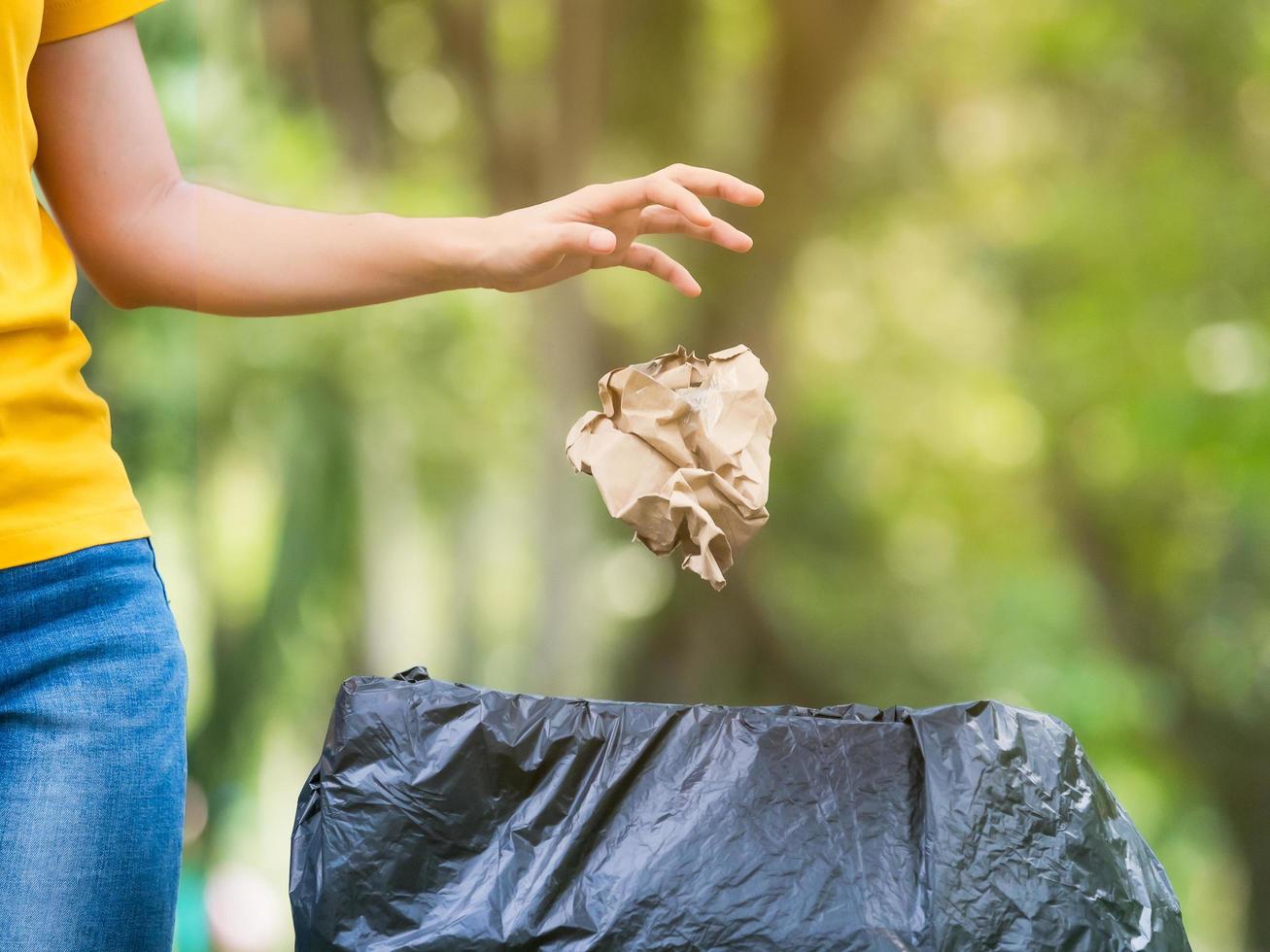 a mulher jogou o saco de papel após o uso no lixo preparado para armazenamento para reciclagem e reutilização foto