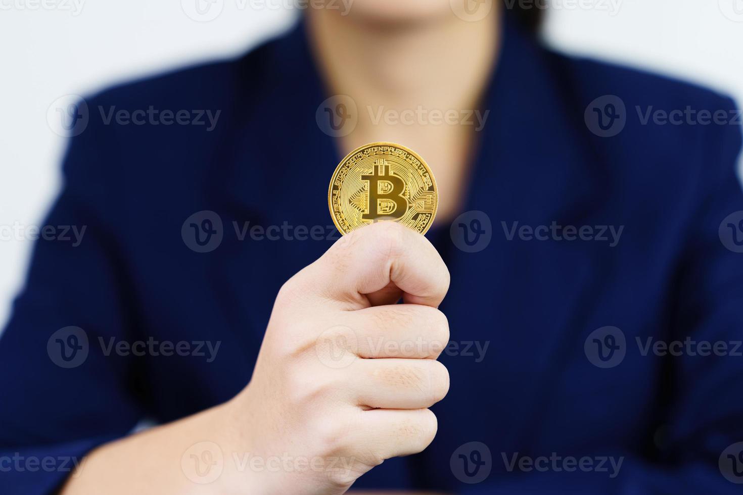 close-up de empresária segurando alguns pedaços de token bitcoin dourado foto