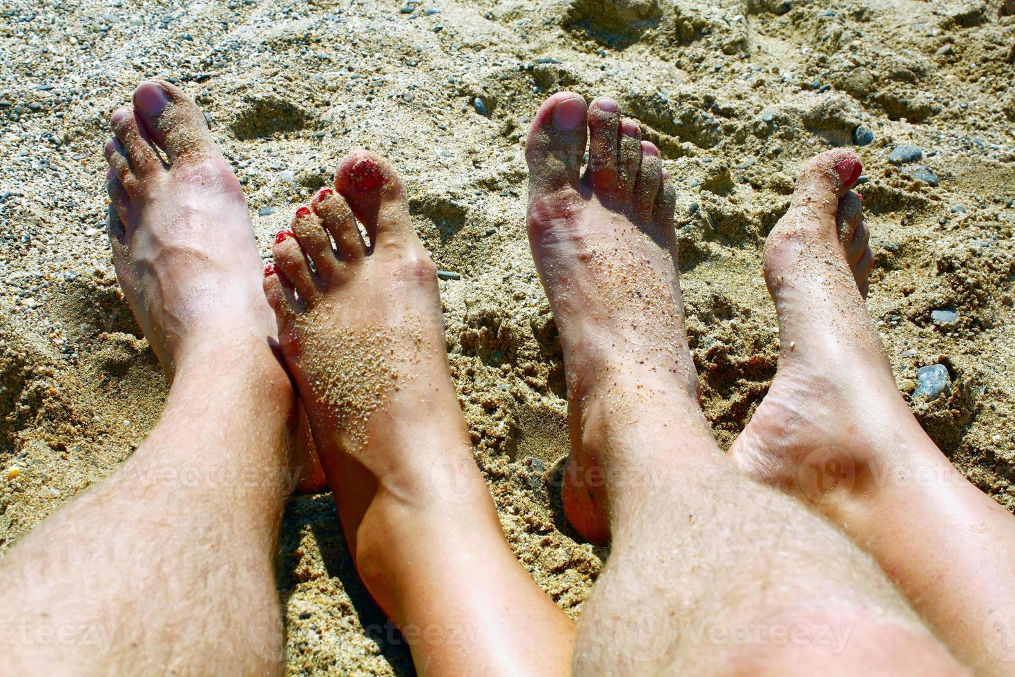 pernas na areia da praia marinha foto