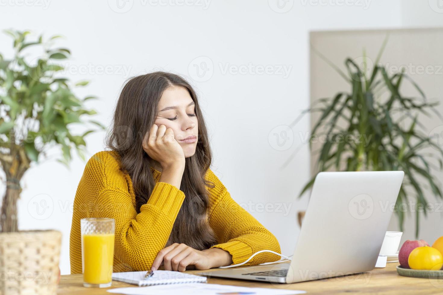 jovem adormeceu na frente do laptop. linda mulher está entediada, cansada ou sobrecarregada. foto