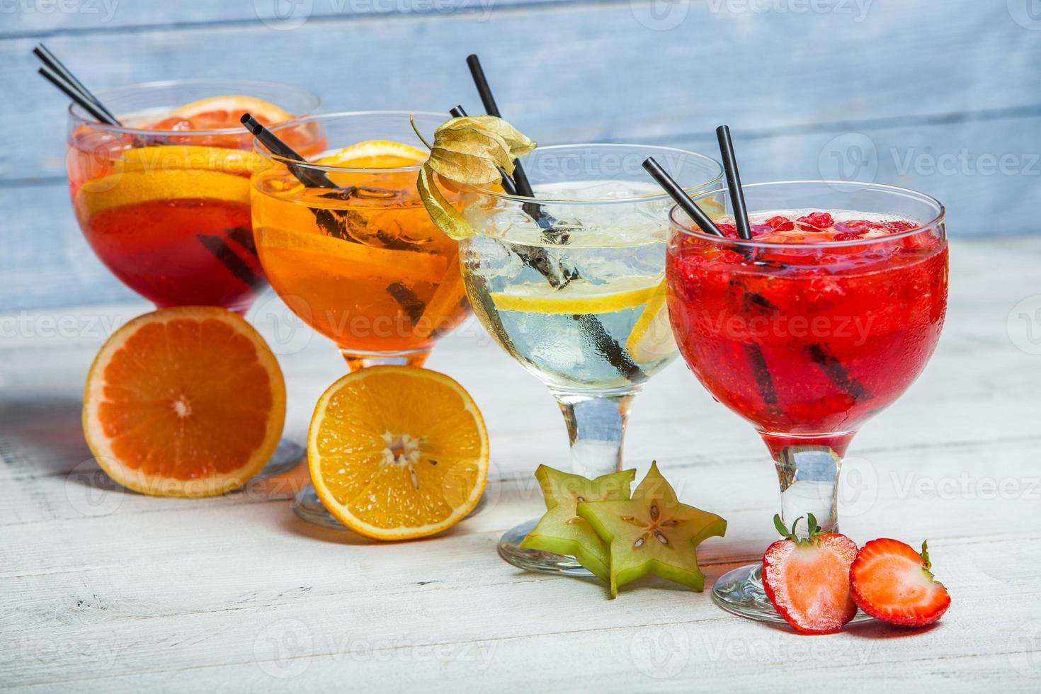 vários coquetéis alcoólicos em fundo branco. coquetéis coloridos fecham. bebida de coquetel de suco de frutas. coquetéis variados. copos de bebidas de frutas com cubos de gelo na mesa no café foto