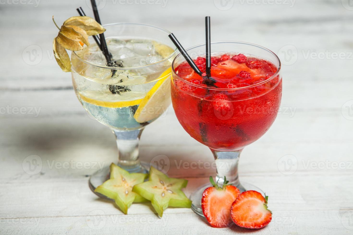 vários coquetéis alcoólicos em fundo branco. coquetéis coloridos fecham. bebida de coquetel de suco de frutas. coquetéis variados. copos de bebidas de frutas com cubos de gelo na mesa no café foto