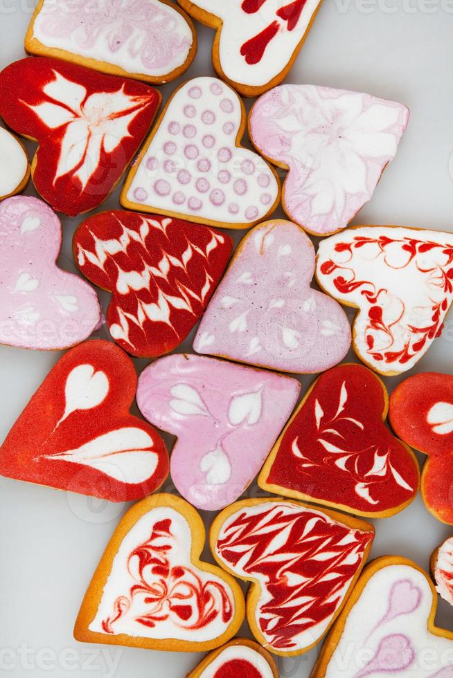 biscoitos de dia dos namorados. biscoitos em forma de coração para o dia dos namorados. biscoitos em forma de coração vermelho e rosa. padrão romântico sem costura com corações de biscoitos. foto