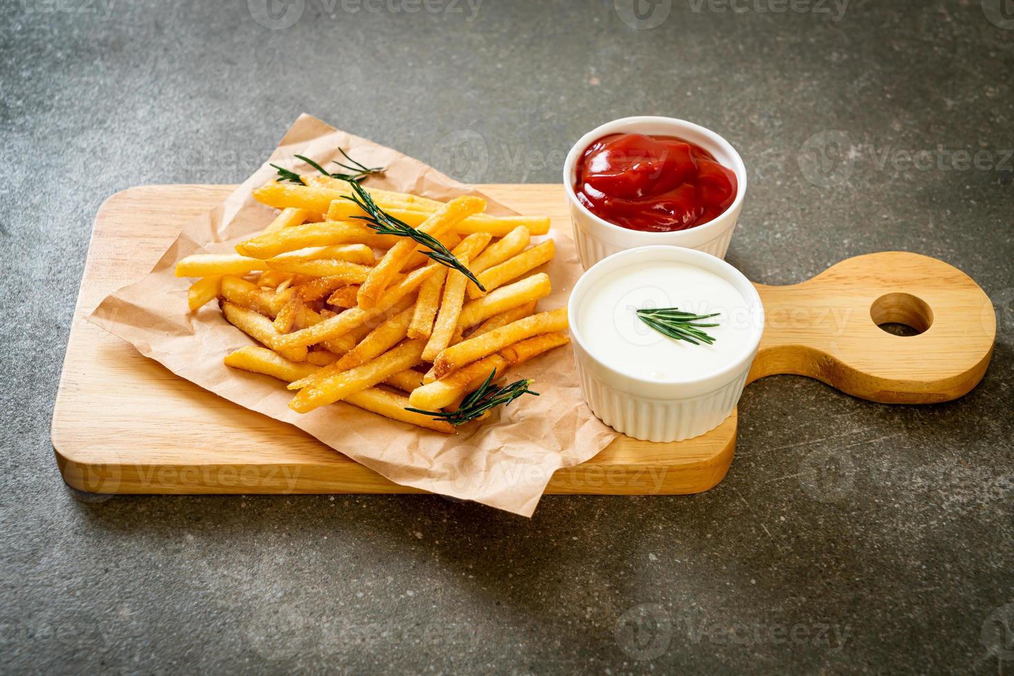 batatas fritas com creme de leite e ketchup foto