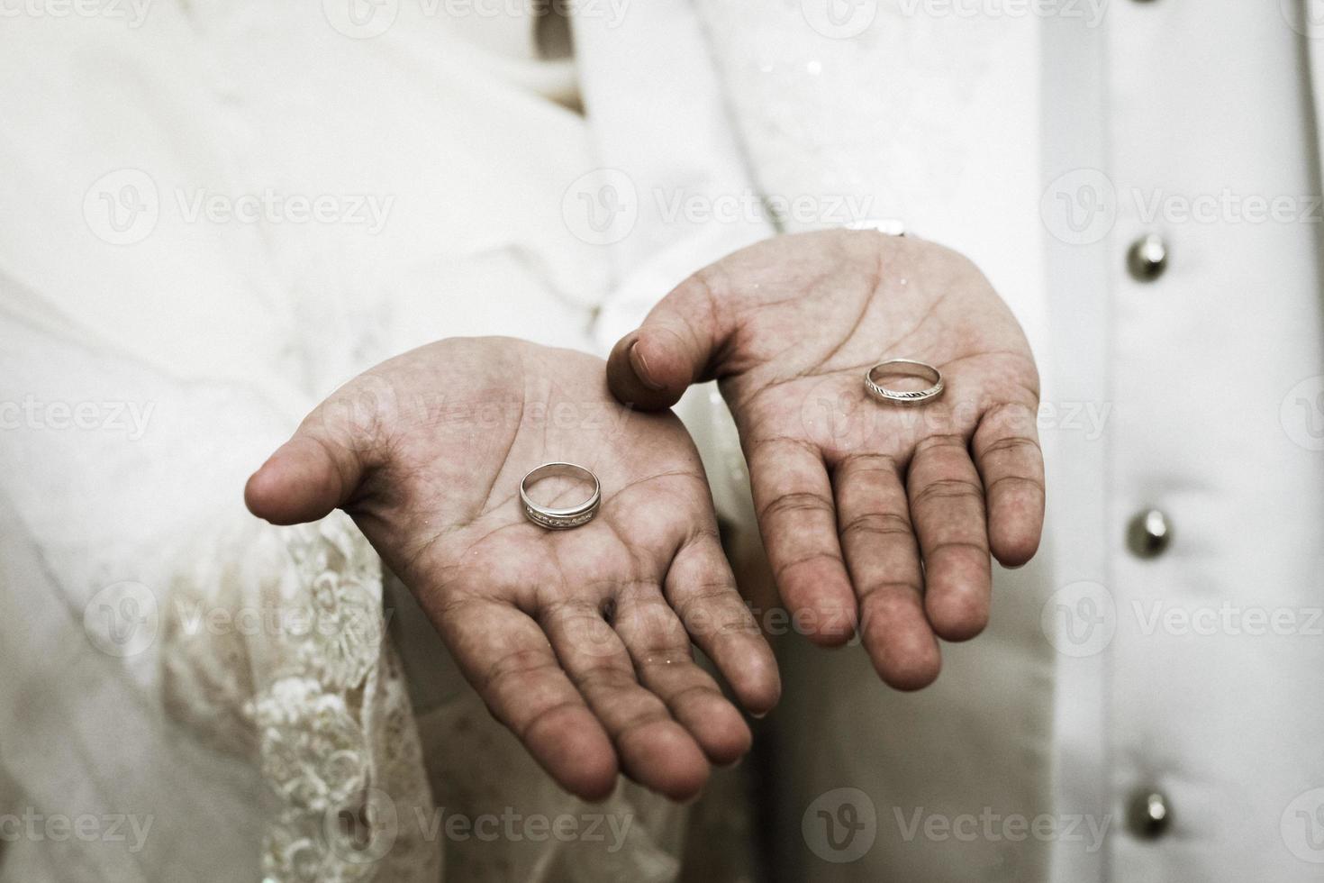 dois anéis de casamento nas mãos do casal foto