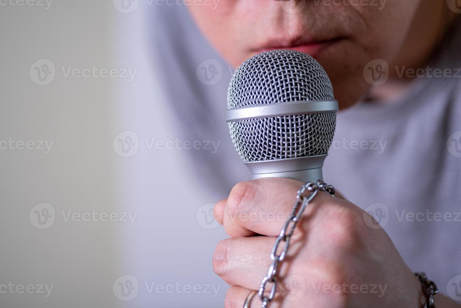 um homem fala em um microfone em close-up. foto