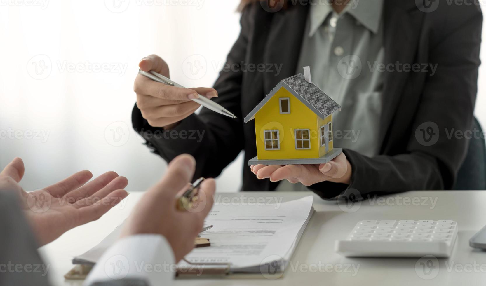 corretor de imóveis apresentando e consultando o cliente para tomada de decisão assinar contrato de formulário de seguro, modelo de casa, sobre oferta de empréstimo hipotecário e seguro de casa. foto