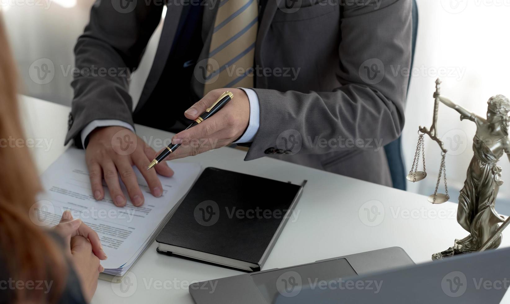 mulher de negócios e advogados discutindo papéis de contrato com escala de latão na mesa de madeira no escritório. direito, serviços jurídicos, aconselhamento, conceito de justiça. foto