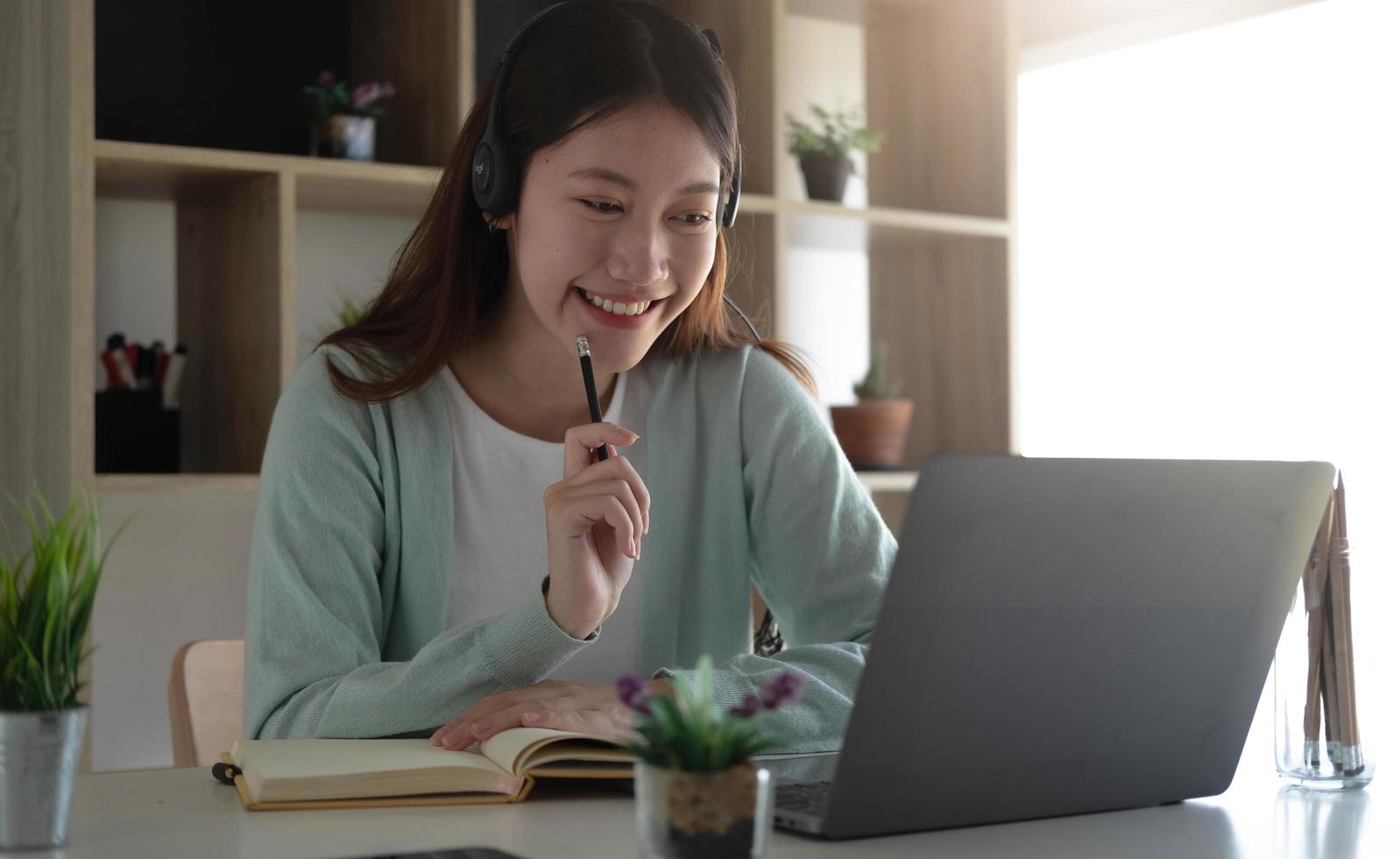 estudantes asiáticos curiosos enquanto estudam on-line na internet e professores de videoconferência de laptop em casa. foto