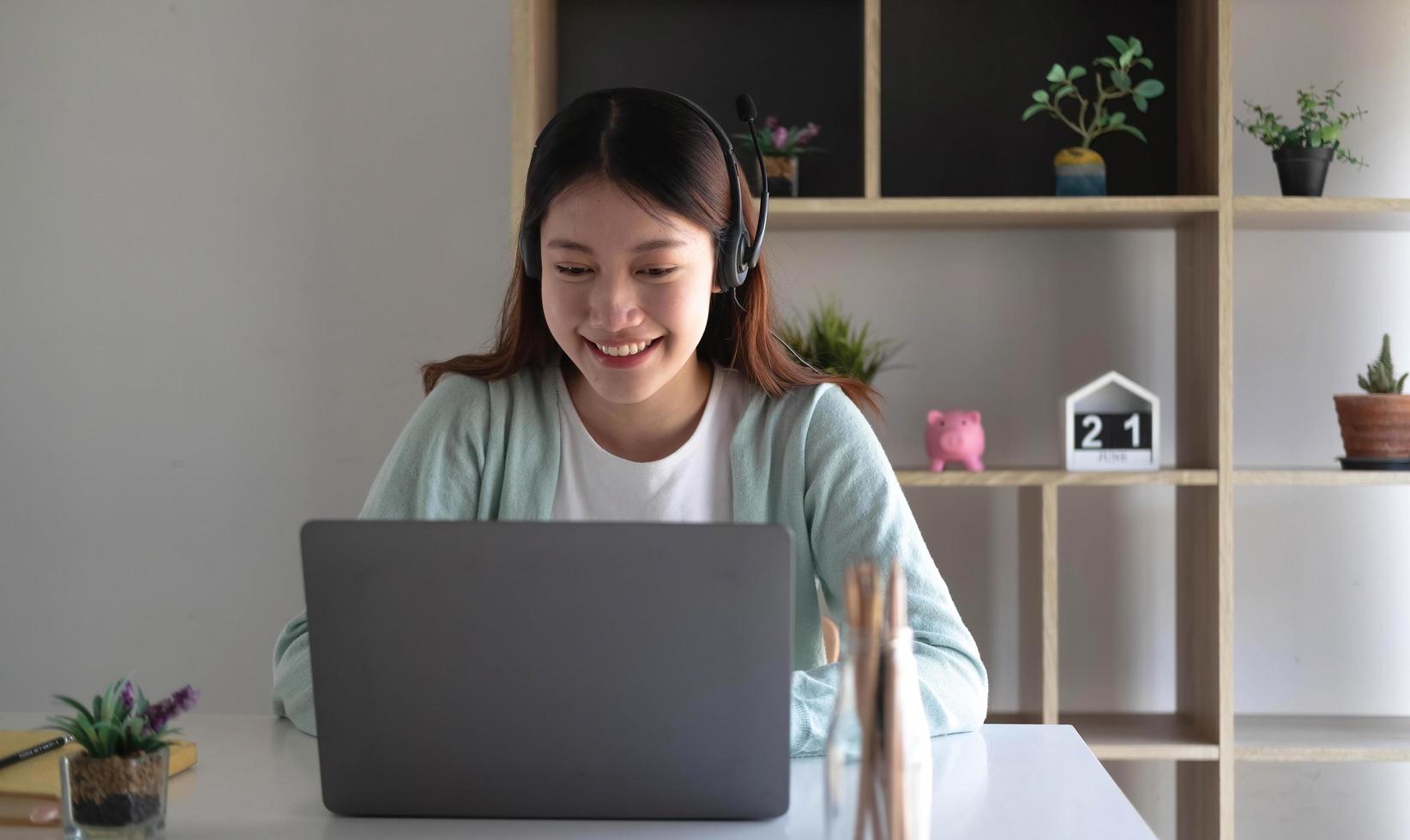 e-learning, online, educação e distanciamento social na internet protegem do conceito de vírus covid-19. mulher asiática estudante videoconferência e-learning com professor no computador portátil em casa. foto