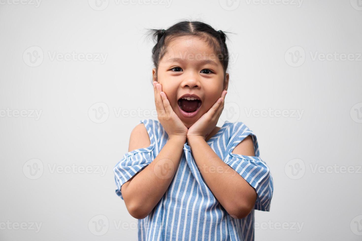 retrato de criança asiática de 5 anos e para colecionar cabelos e um grande sorriso em fundo branco isolado, ela é felicidade, brilho na juventude foto