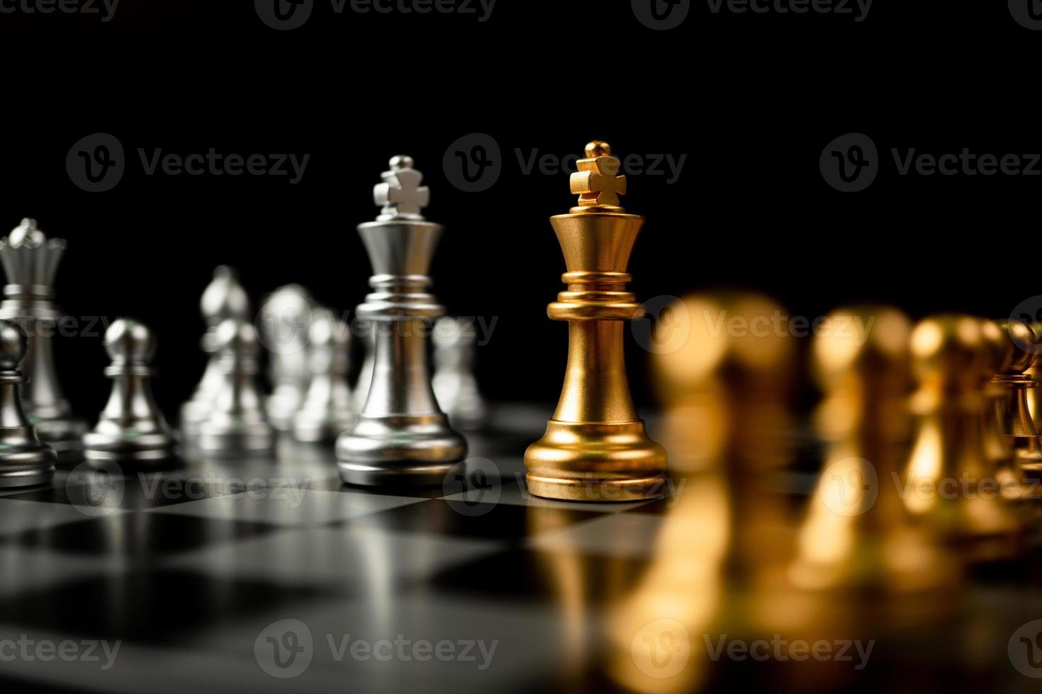 peças de xadrez douradas e prateadas convidam cara a cara e há peças de xadrez ao fundo. conceito de competição, liderança e visão de negócios para uma vitória em jogos de negócios foto