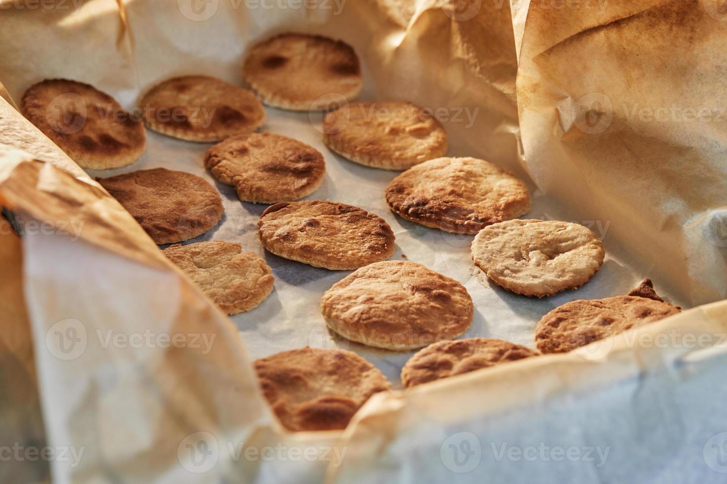 os círculos de massa estão prontos depois de assar no forno para aperitivo com queijo ricota e tomate cereja foto