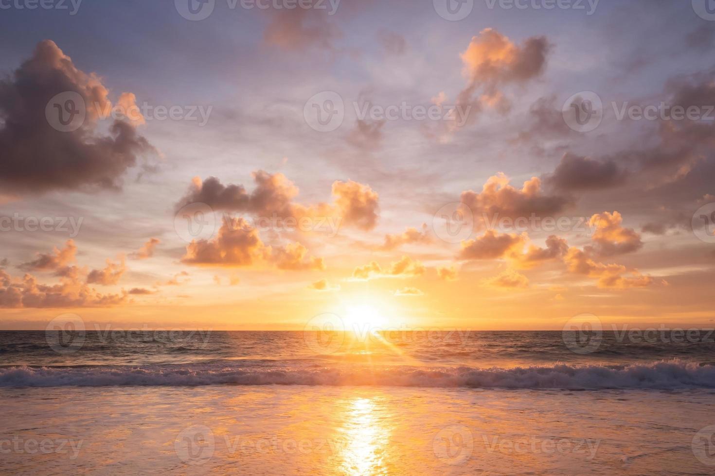 um belo reflexo do pôr do sol no horizonte entre o mar e o céu com as nuvens, praia de chapéu mai khao, phuket tailândia. foto