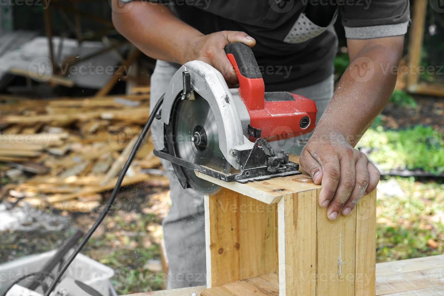 carpinteiro asiático está serrando a madeira. foto