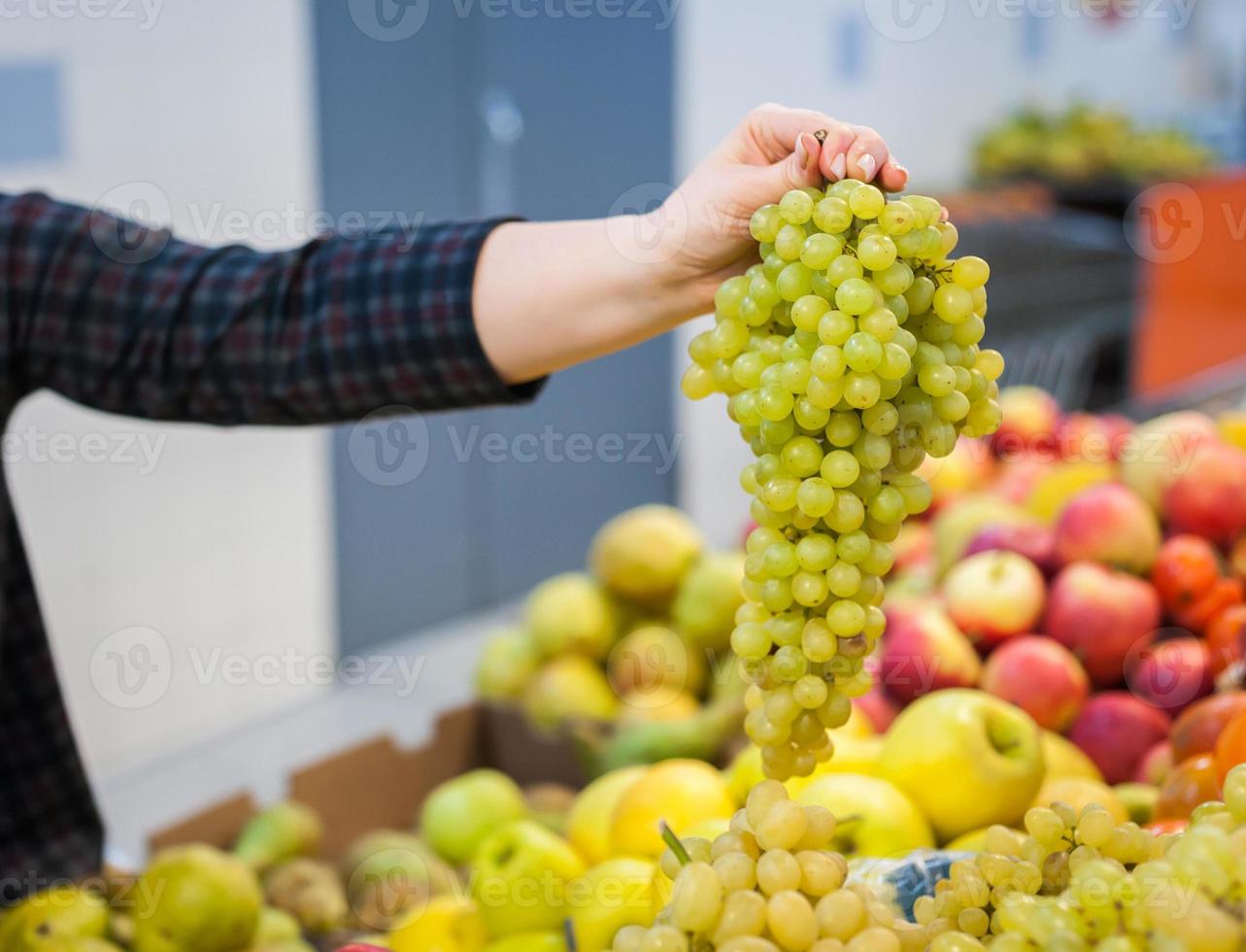 garota caucasiana comprando produtos alimentares de legumes frescos no mercado foto