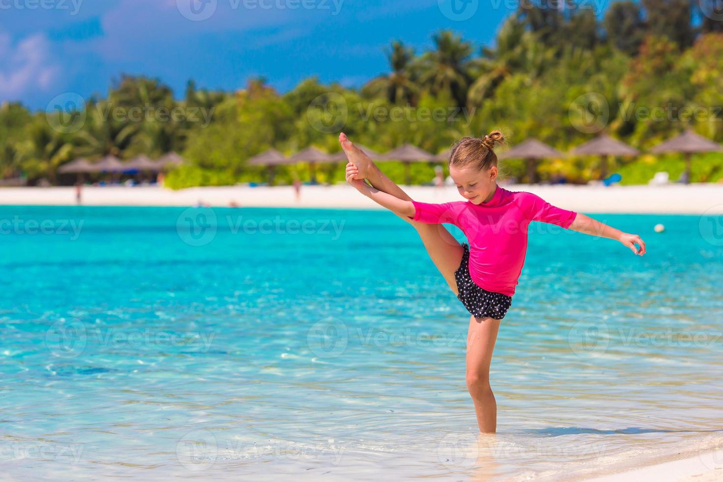 menina adorável na praia durante as férias de verão foto