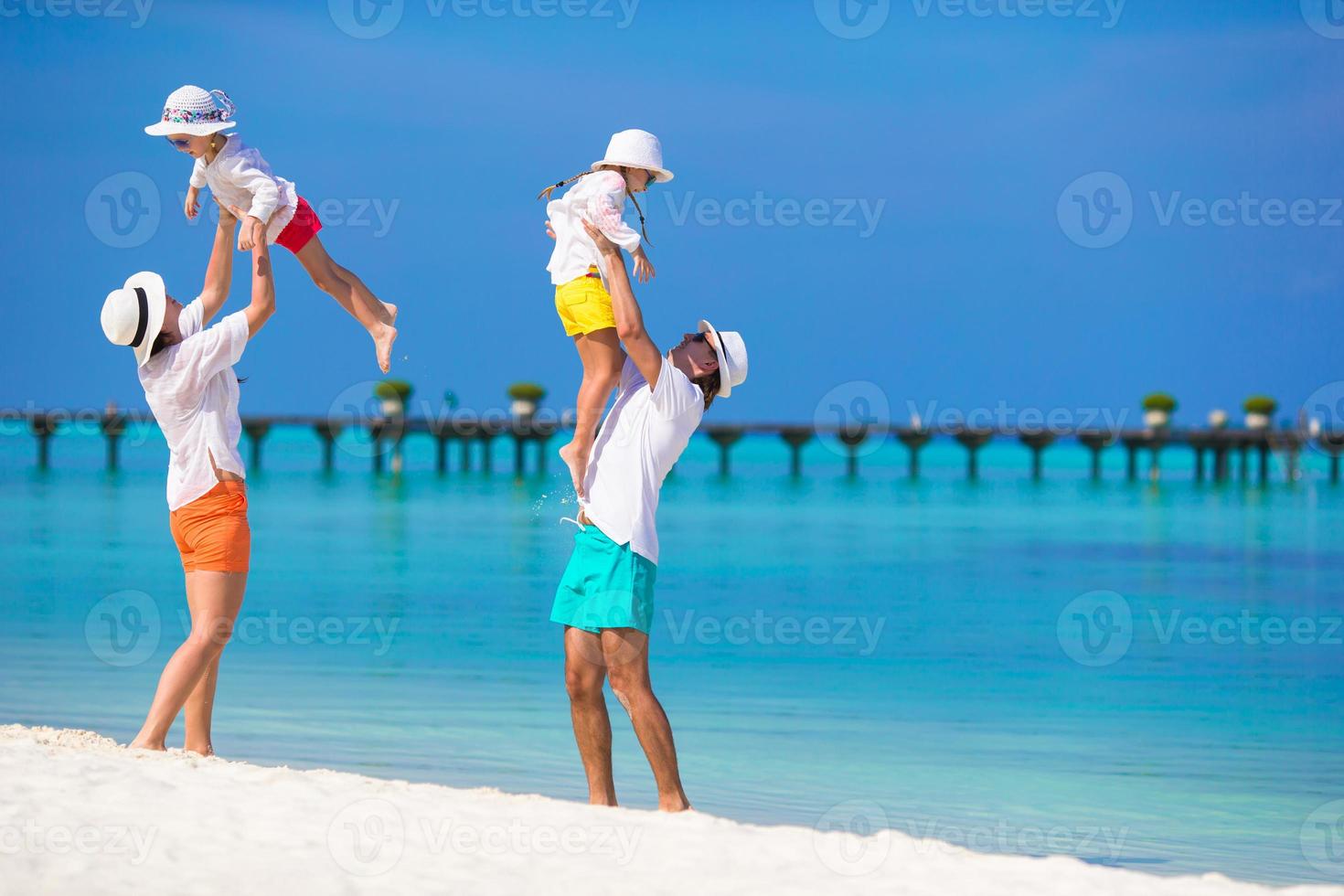 família feliz durante as férias na praia foto
