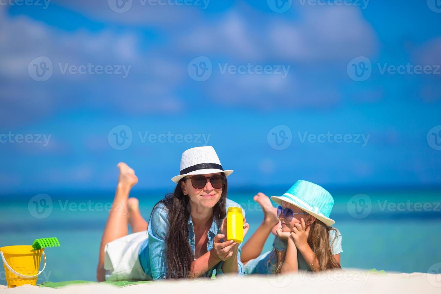 mãe e filho com protetor solar na praia tropical foto