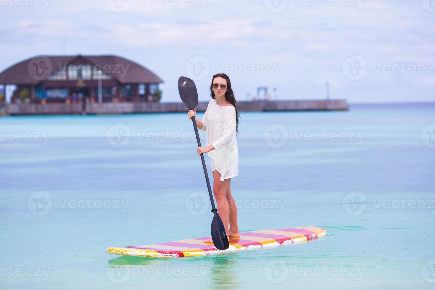 jovem ativa na prancha de stand up paddle foto