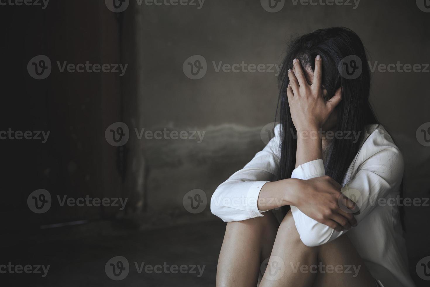 mulheres sentadas no chão chorando com depressão, mulher deprimida, problemas familiares, estresse, cozinha, abuso, violência doméstica, o conceito de depressão e suicídio. foto