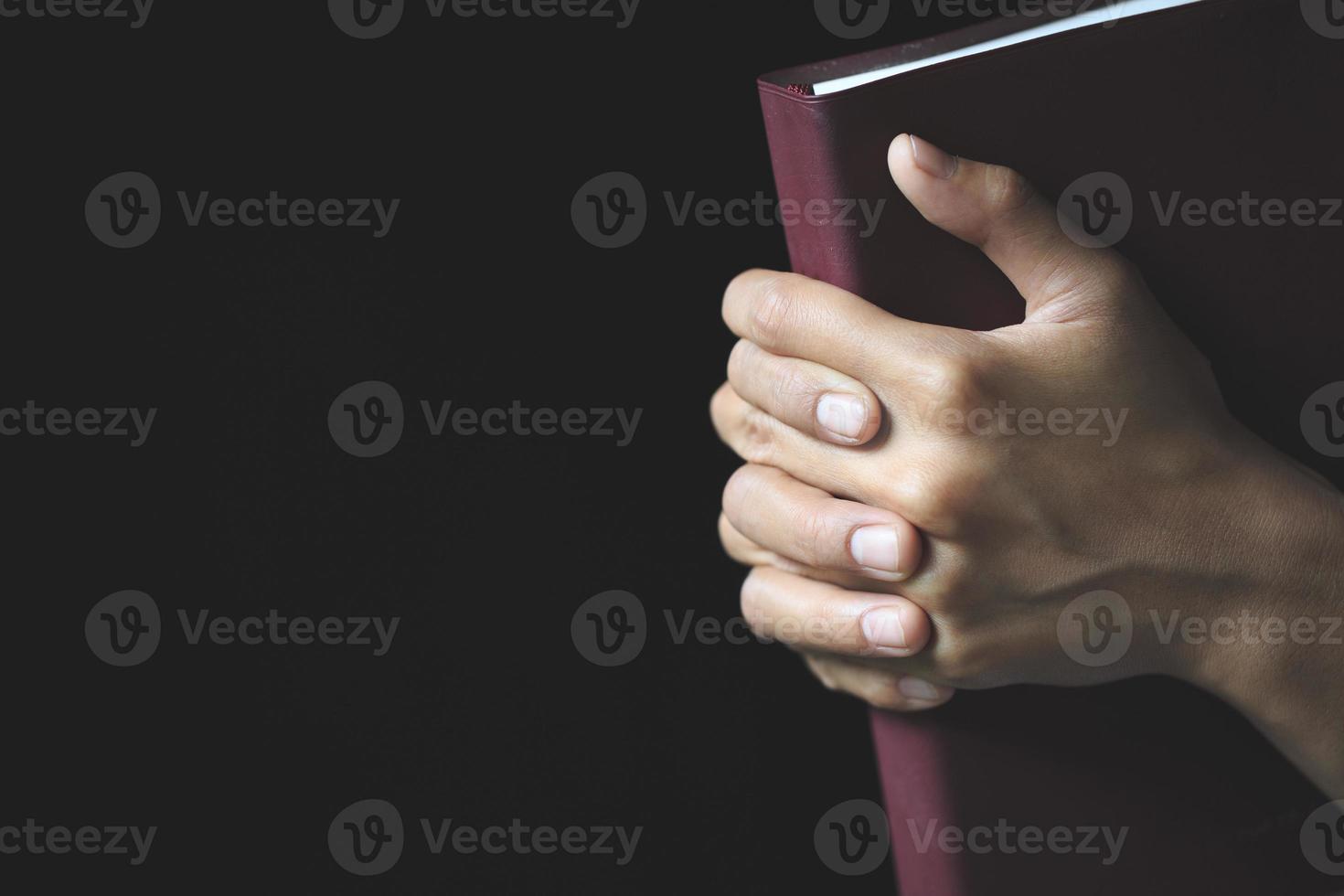 mãos dobradas em oração em uma bíblia sagrada no conceito de igreja para fé, espiritualidade e religião, adoração, pecados e oração. foto