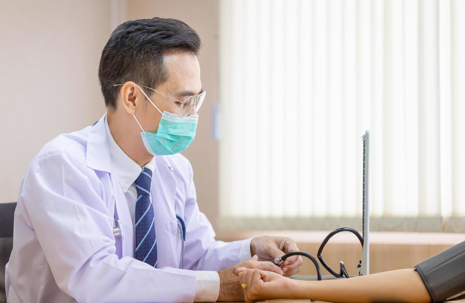 médico usando esfigmomanômetro verificando a pressão arterial de um paciente, médico verificando a pressão arterial foto