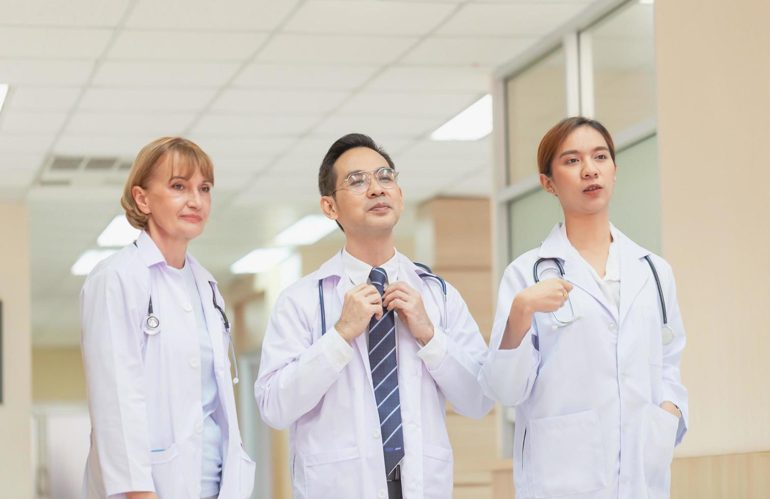 equipe médica discutindo no corredor do hospital, equipe de médicos mestiços, grupo de médicos multiétnicos, homens e mulheres conversando e discutindo foto