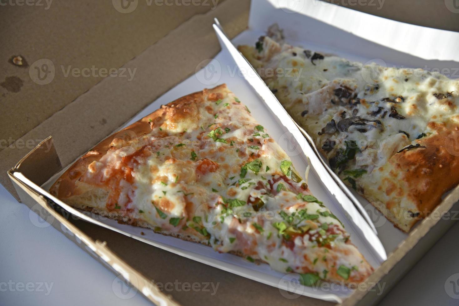 uma fatia de pizza em uma caixa de papelão foto